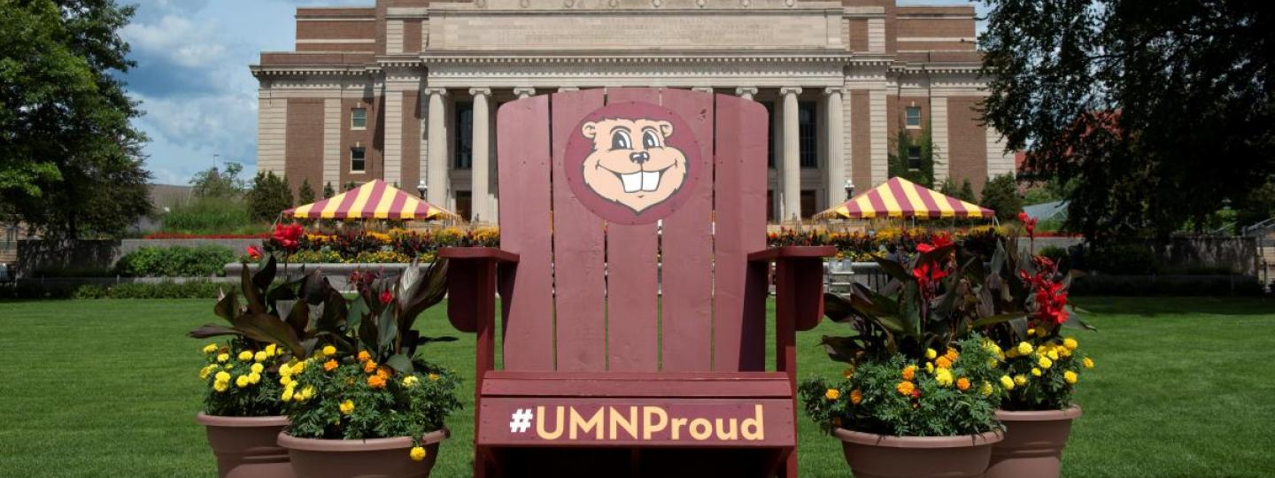 Oversized maroon Adirondack chair with Goldy Gopher and "#UMNProud" graphics.
